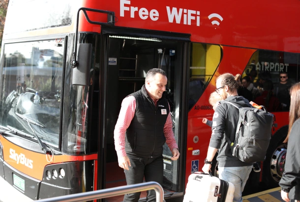 A SkyBus onboarding Travellers for an Airport Transfer