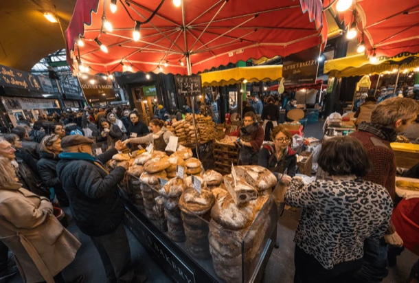 The Borough Market in London with people buying bread and walking throughout the market