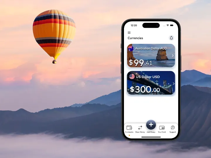 A smartphone displaying a currency conversion app with AUD and USD amounts. A hot air balloon in a scenic mountain background.