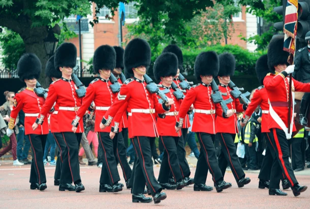 London guards walking in the street with people watching them in the background