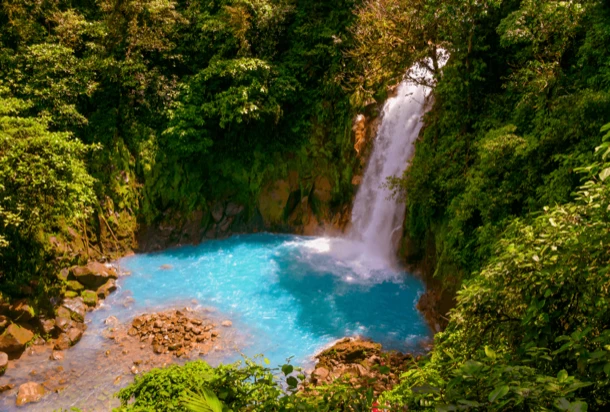 Scenic waterfall in Costa Rica surrounded by lush greenery and rocks.